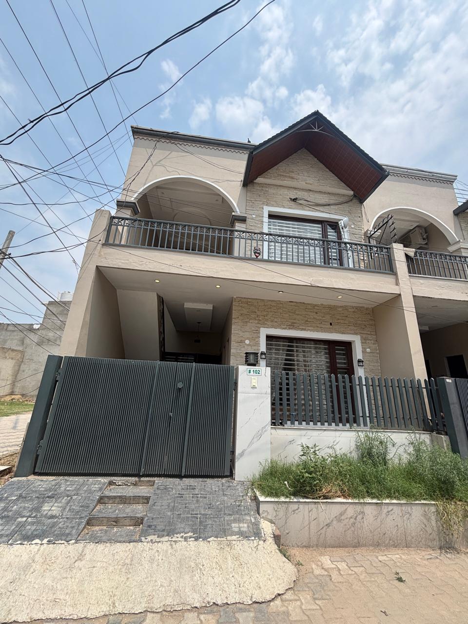 Beige two-storey house with arched balconies and a gabled wooden roof